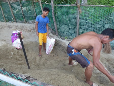 Two guys excavating the hatchery site and replacing the sand